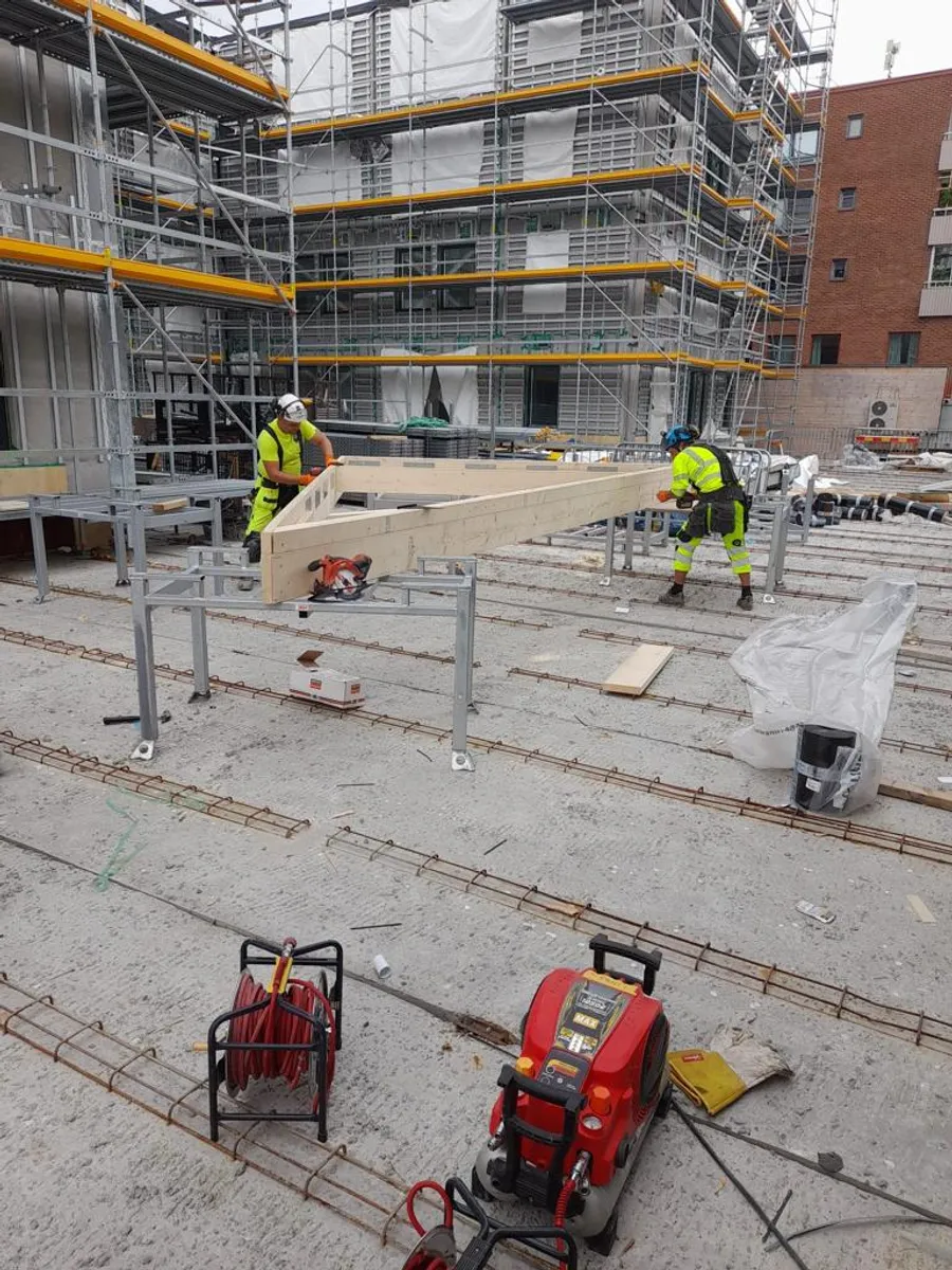 Yrkesarbetare monterar takstolar på betongbjälklag
